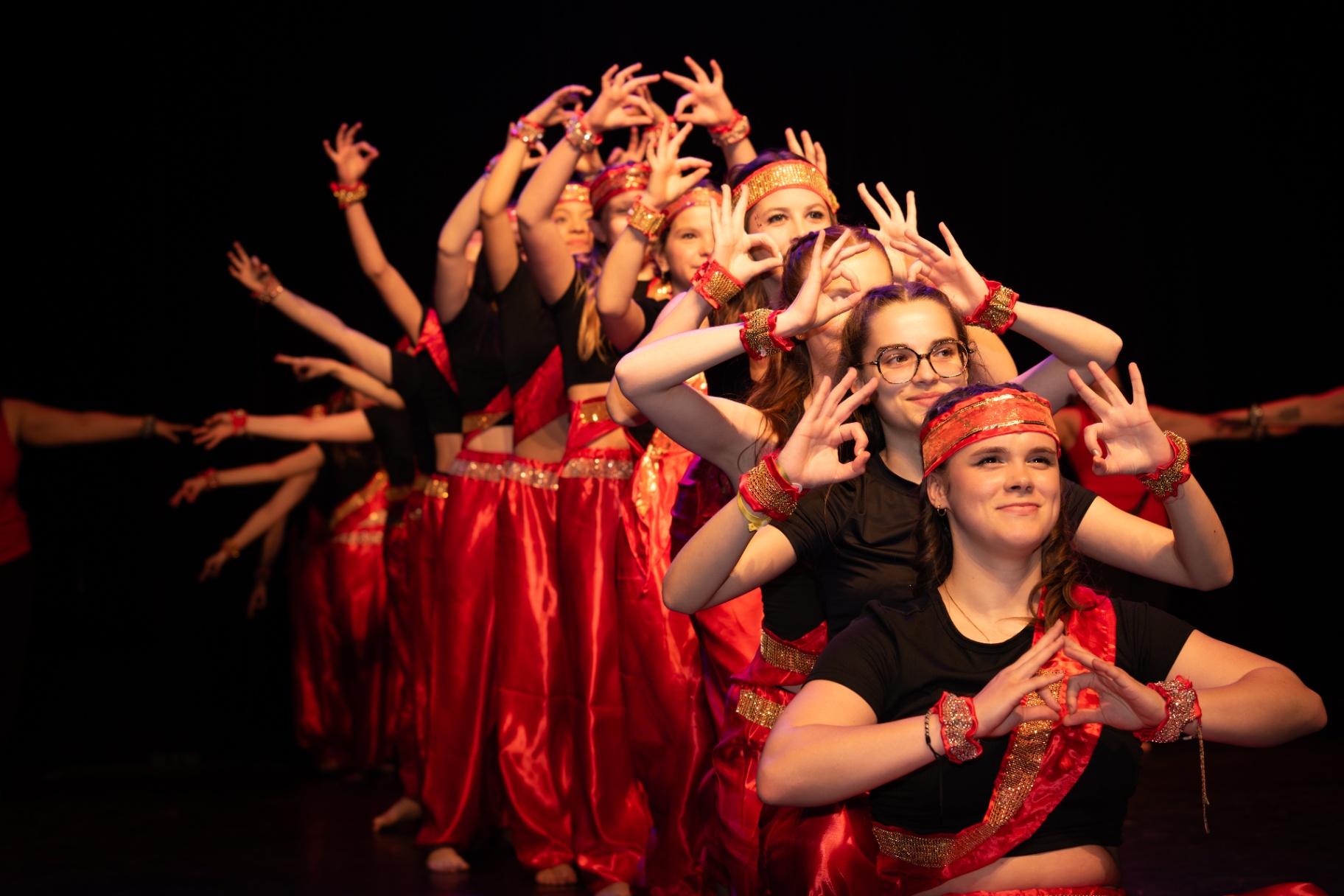 Groupe de danseuses en sarouels rouges, pose synchronisée d'inspiration indienne