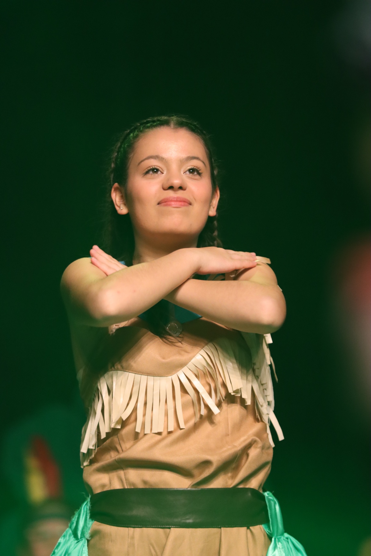 Jeune danseuse aux tresses, bras croisés sur les épaules, allure Pocahontas