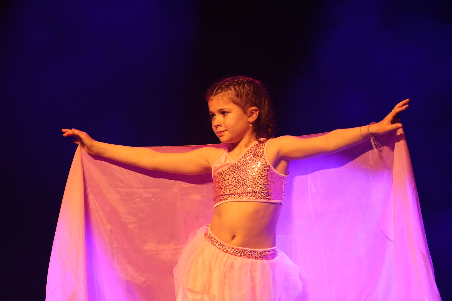 Jeune danseuse orientale déployant un voile rose